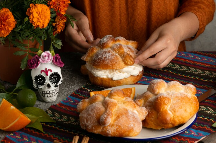 Three pieces of Pan de Muerto on a Day of the Dead themed table, showing different ways to enjoy this traditional Mexican bread